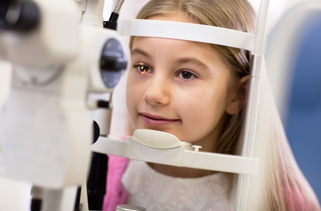 Young girl having her eye examined by an optometrist