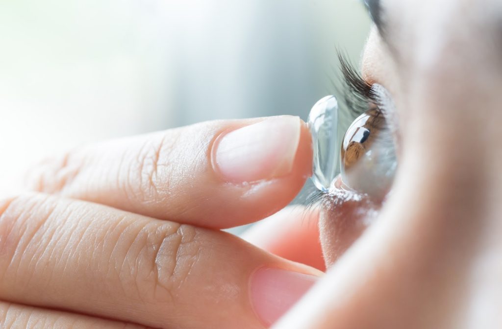 Woman putting contact lens in her eyes.