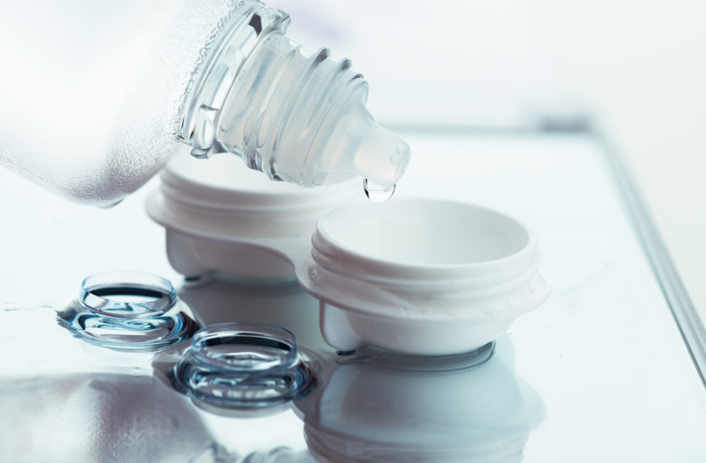 Contact lens case being filled up with solution with lenses on side of table