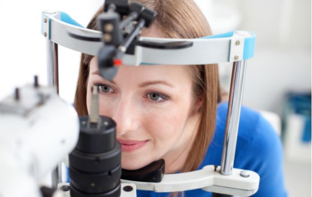 Young women undergoing eye exam at optometrist office