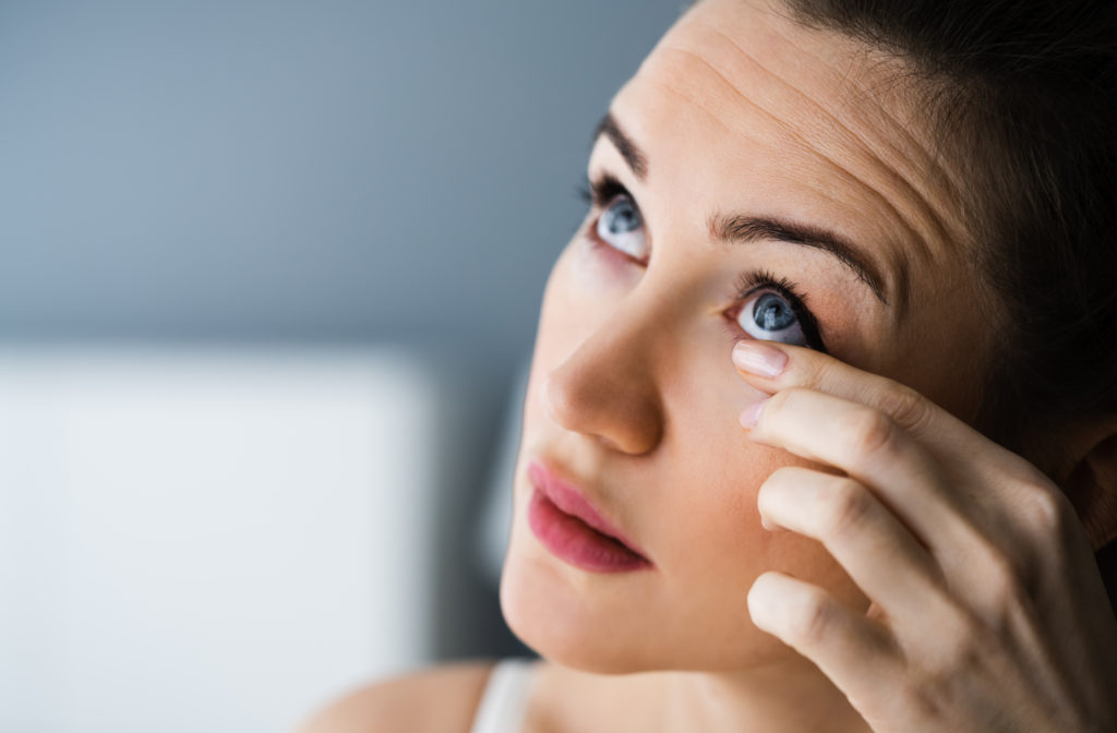Women experiencing itching eyes touching her eye lid to see what is wrong with her vision
