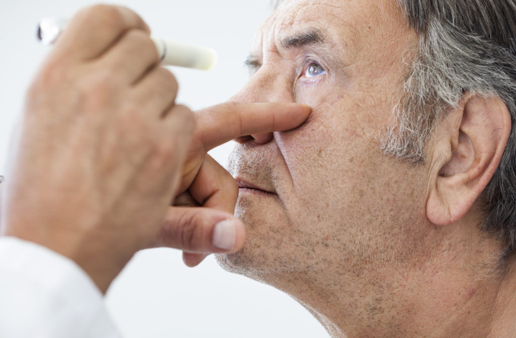 Man having eye examined by optometrist at eye clinic
