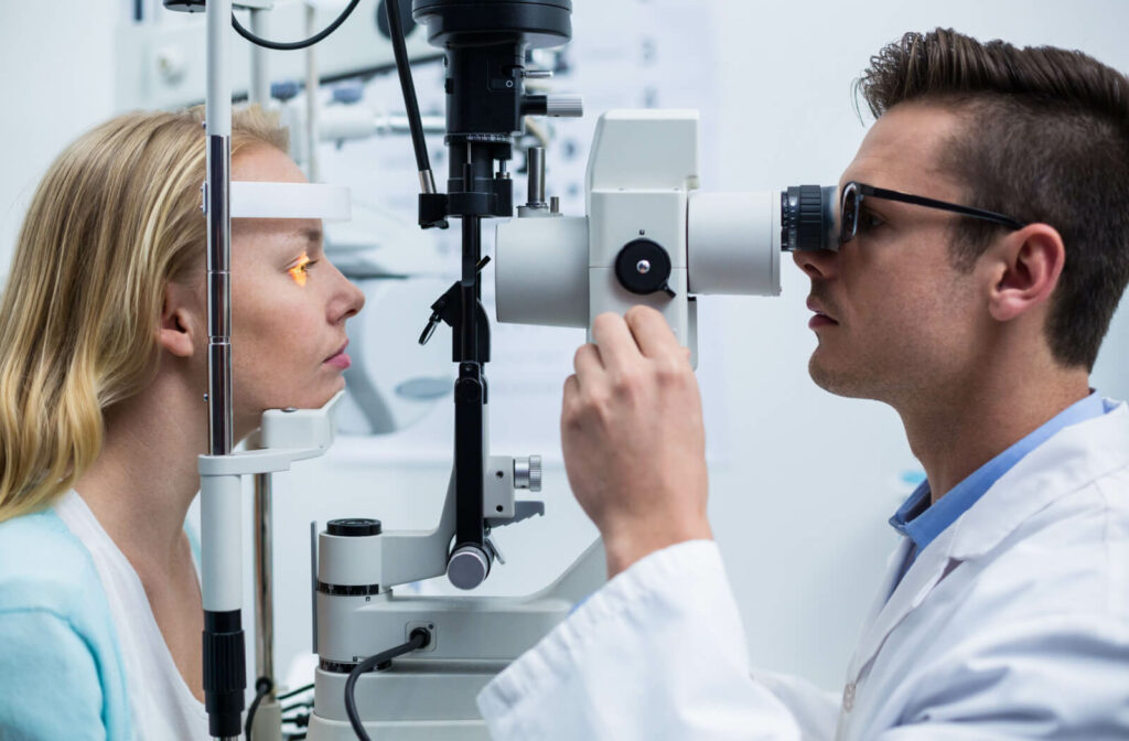 A male optometrist examining the eyes of a woman using a medical device to detect potential eye problems.